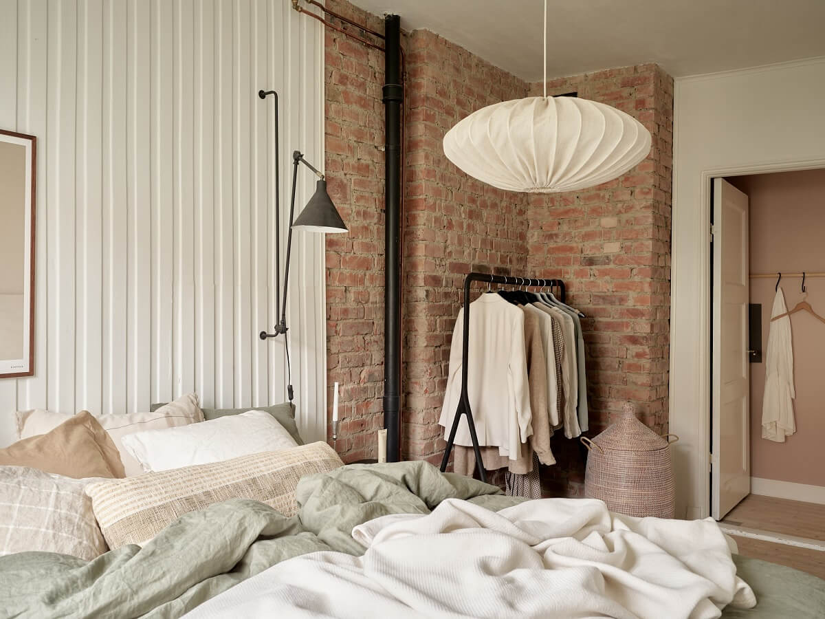 A Swedish Apartment with a Dark Blue Living Room and Exposed Brick 14 bedroom with wood and brick wall