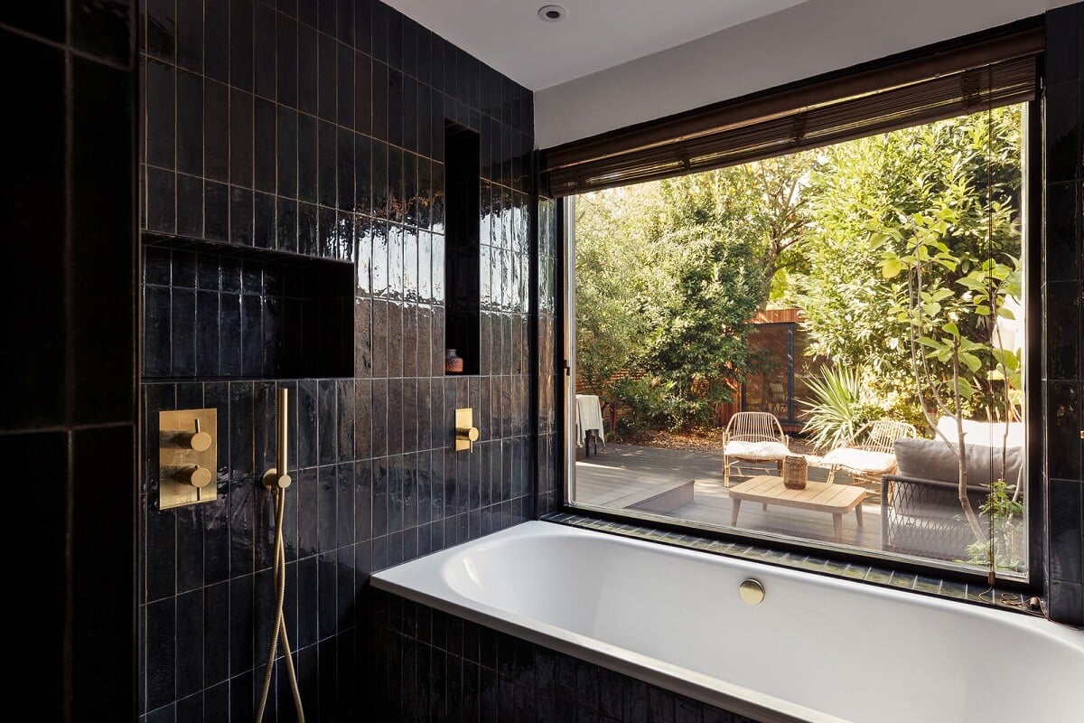 A Warm Ground Floor Apartment with Reclaimed Materials 11 black bathroom with bath and picture window