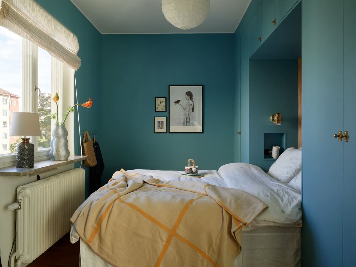 A Midcentury Swedish Apartment with Bold Colors 12 blue bedroom with built in wardrobes