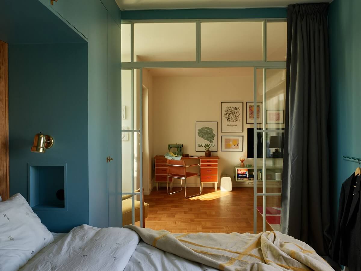 A Midcentury Swedish Apartment with Bold Colors 15 blue bedroom with glass door
