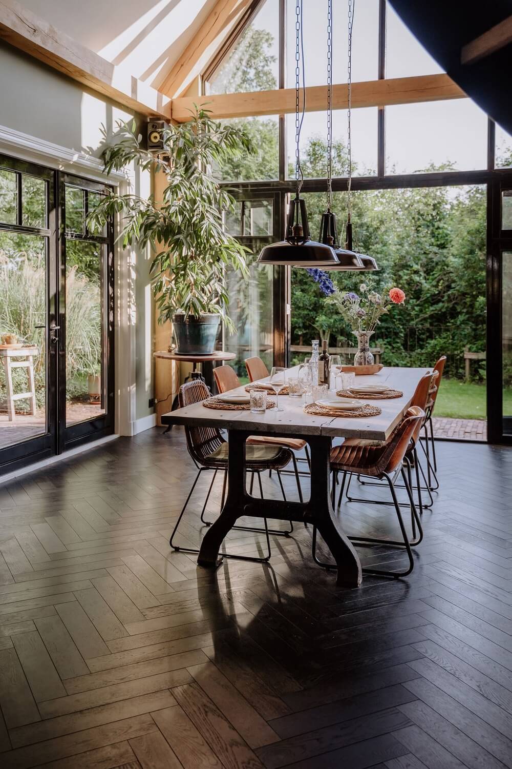 Historic Charm in a New Country House in The Netherlands 2 dining room with piched ceiling glass wall and wooden beams