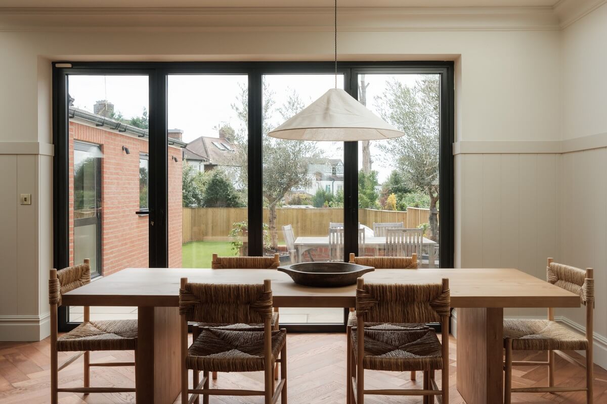 A Calm Color Palette and Warm Materials in a London Home 14 dining table in front of garden doors