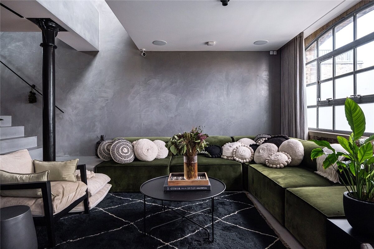 An Industrial, Loft-Style Duplex with Japanese Landscaped Roof Terraces 2 gray liivng room with green corner sofa and industrial window