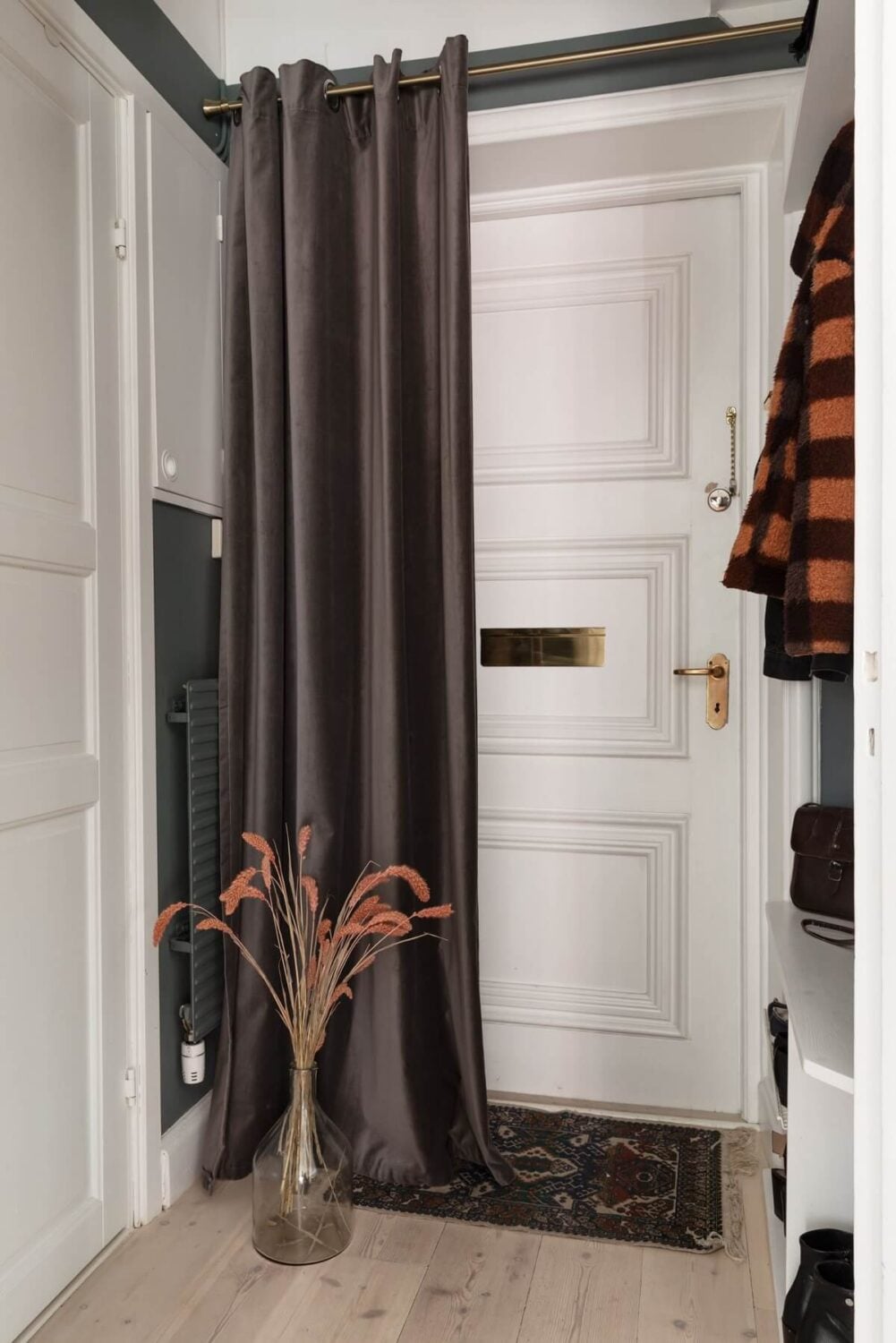 A Stockholm Studio Apartment with Warm Earthy Textiles 18 hallway with curtain in front of the door