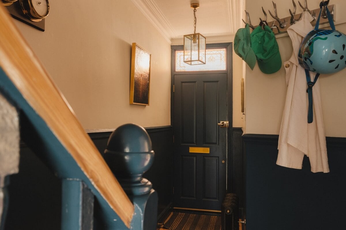 A Charming Victorian House with a Lovely Kitchen 5 hallway with dark blue paneling