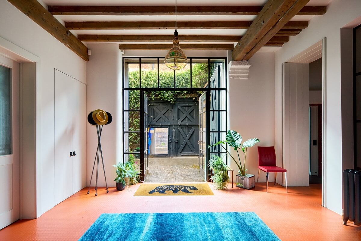 An Industrial and Colorful Warehouse Conversion in London 10 hallway with steel glass door and wooden beams