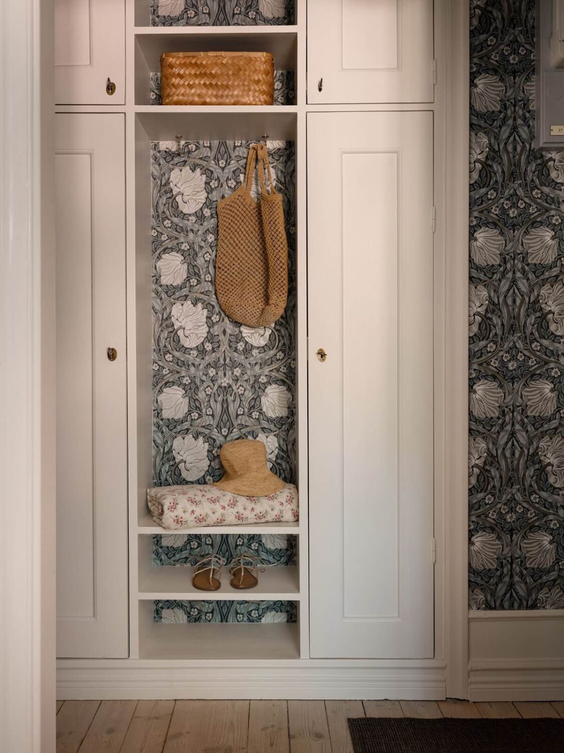 A Light and Well-Planned Apartment in Stockholm 18 hallway with storage cabinets and william morris wallpaper nordroom