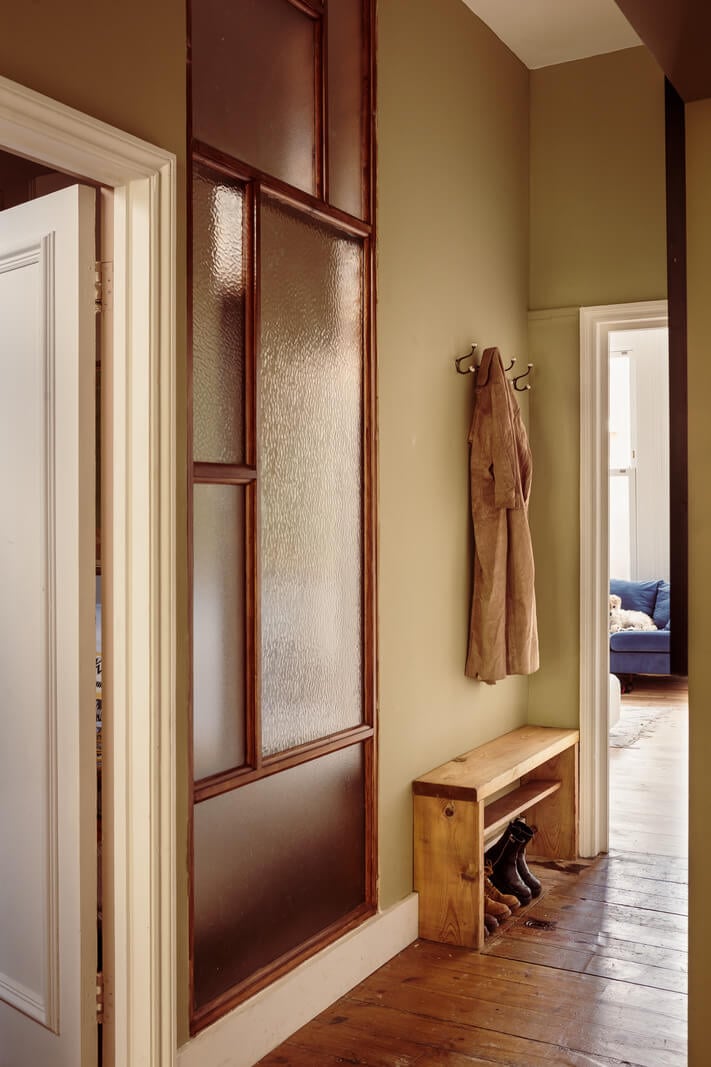 A Warm Ground Floor Apartment with Reclaimed Materials 17 hallway with window and shoe storage