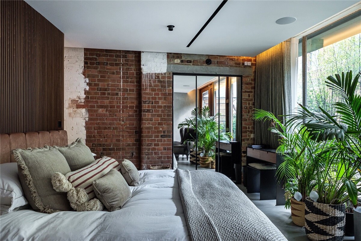 An Industrial, Loft-Style Duplex with Japanese Landscaped Roof Terraces 15 industrial bedroom with brick wall and large mirror