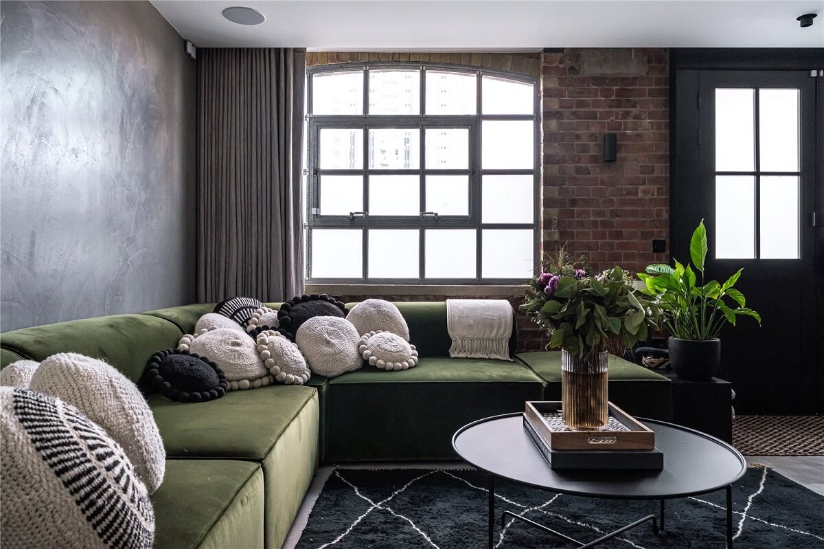 An Industrial, Loft-Style Duplex with Japanese Landscaped Roof Terraces 3 industrial living room with brick wall and green sofa