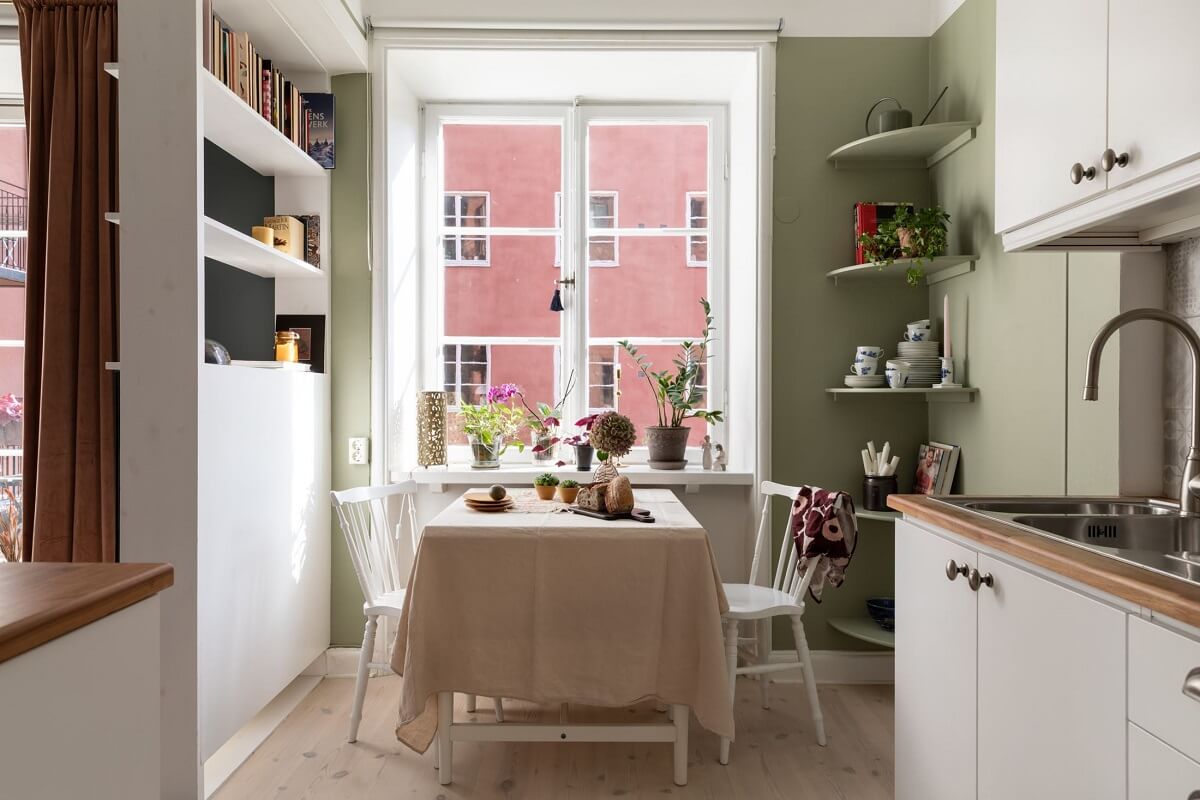 A Stockholm Studio Apartment with Warm Earthy Textiles 14 kitchen green wall dining table