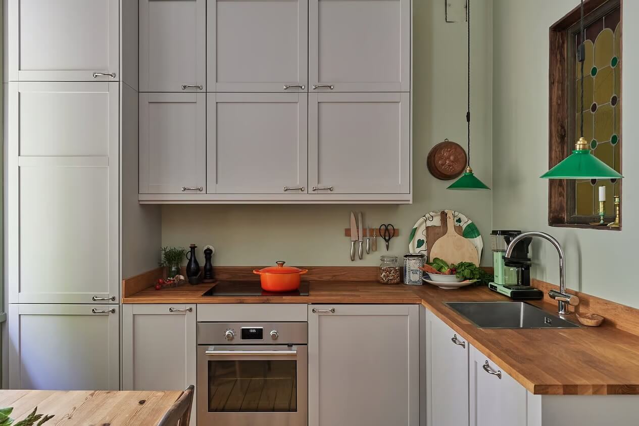 Soothing Colors and Smart Solutions in a Two Bedroom Apartment 4 kitchen with green pendants and stained glass window