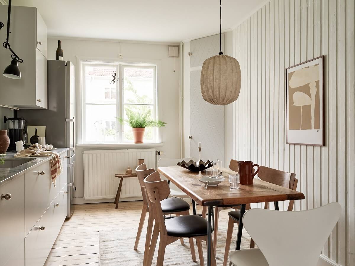A Swedish Apartment with a Dark Blue Living Room and Exposed Brick 7 kitchen with wooden wall and table