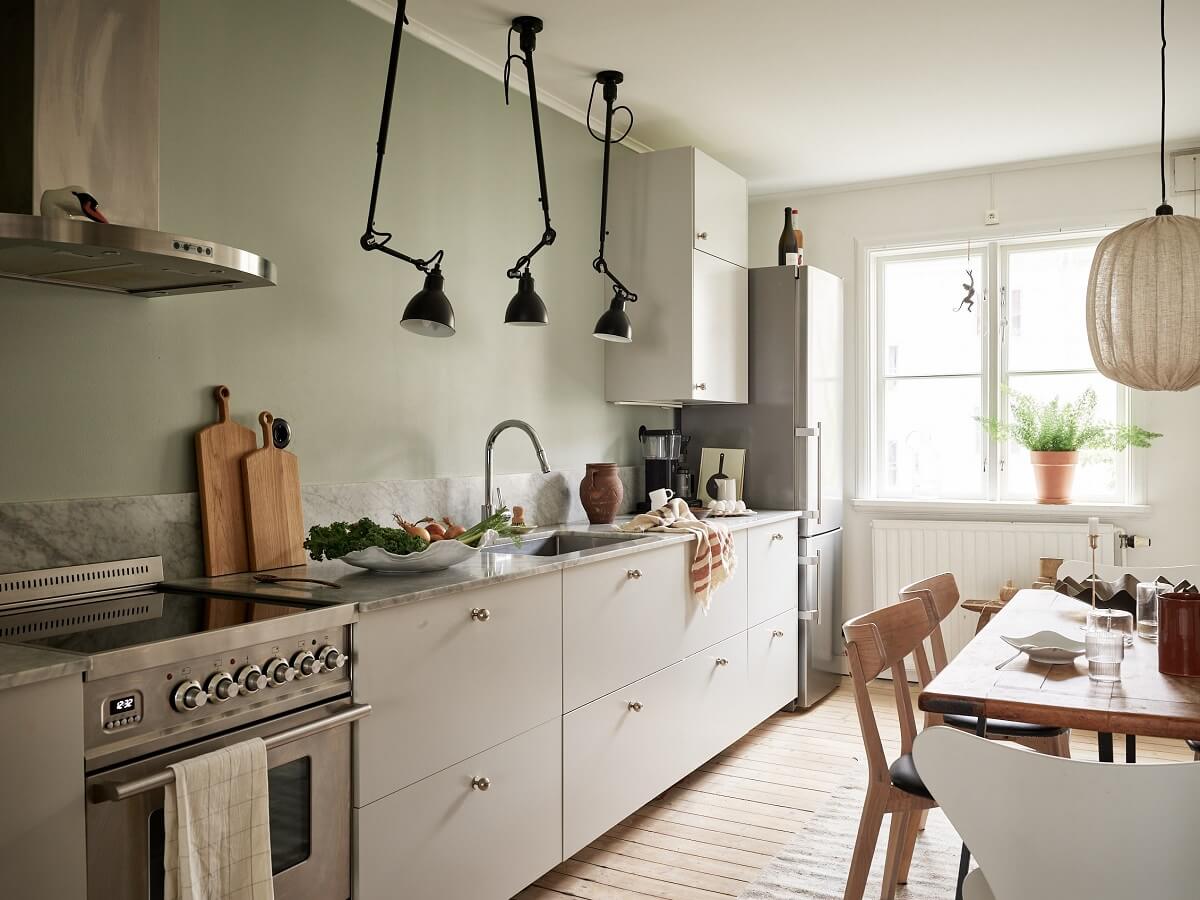 A Swedish Apartment with a Dark Blue Living Room and Exposed Brick 8 light scandinavian kitchen