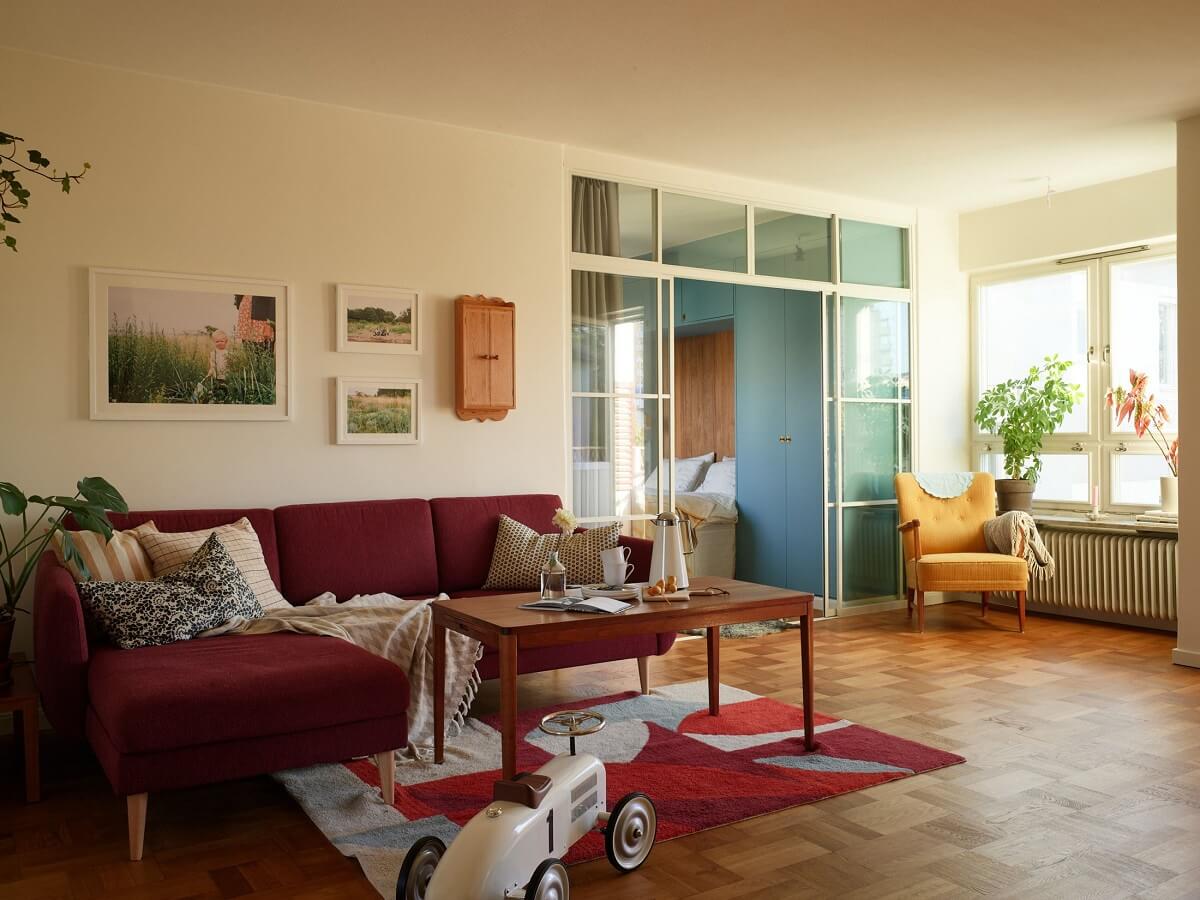 A Midcentury Swedish Apartment with Bold Colors 1 living room parquet floor red sofa