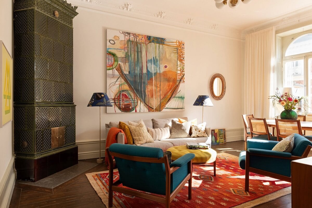 living room with green fireplace red rug and blue chairs