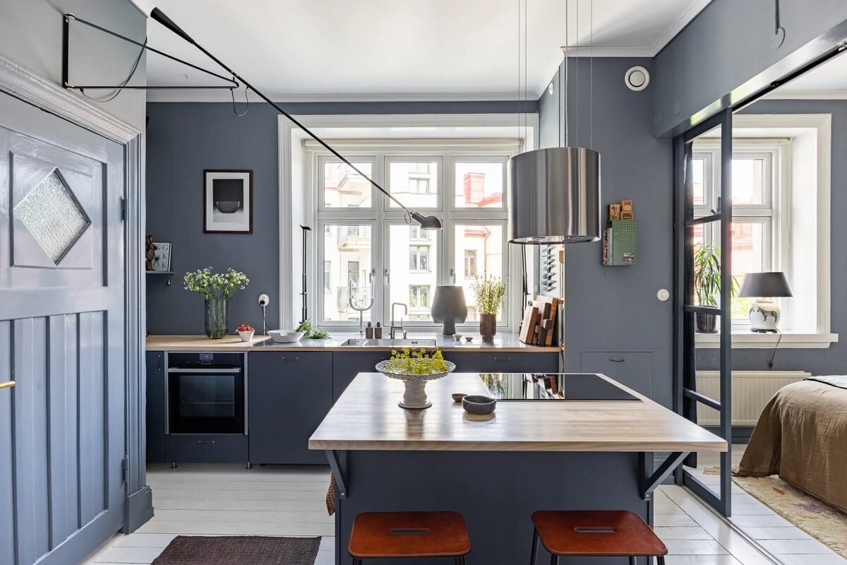 A Swedish Apartment with a Moody Kitchen and Bedroom 6 moody gray blue kitchen with island and steel doors to bedroom A Swedish Apartment with a Moody Kitchen and Bedroom