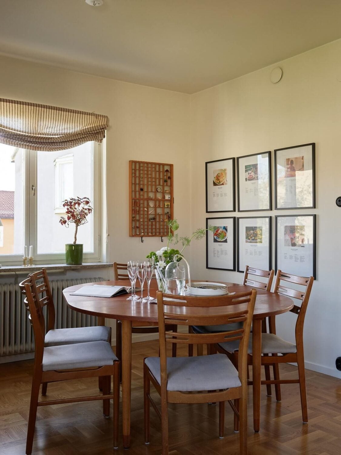 A Midcentury Swedish Apartment with Bold Colors 8 round wooden dining table