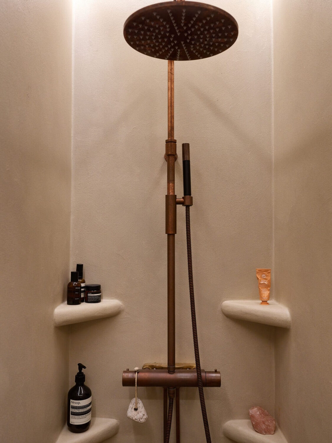 A Studio Apartment with Plaster Walls and a Walnut Kitchen 17 shower with small corner shelves
