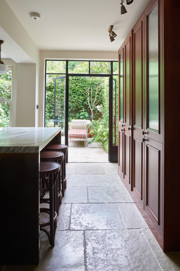 A Luxurious Two-Bedroom Maisonette in Primrose Hill 4 stone floor kitchen with island and floor to ceiling wooden cabinets
