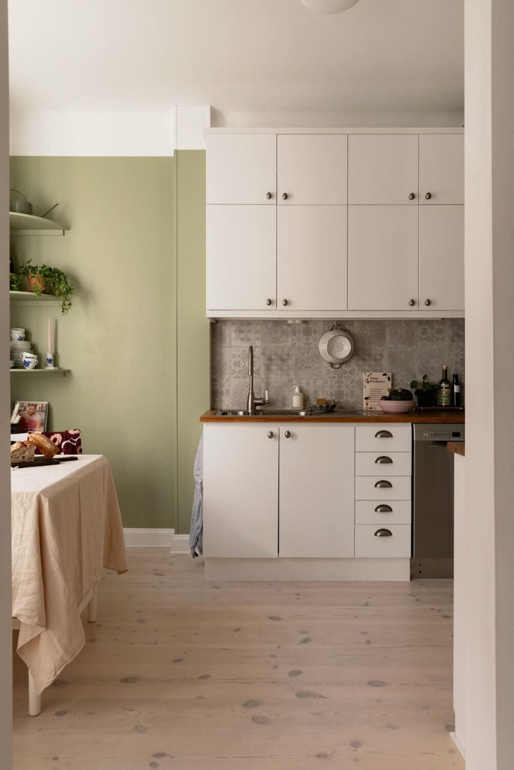 A Stockholm Studio Apartment with Warm Earthy Textiles 13 studio white kitchen with green walls
