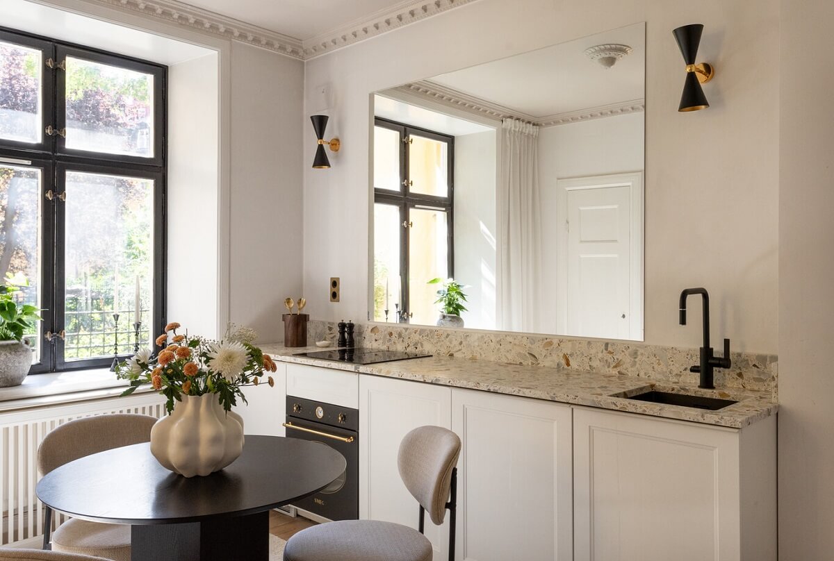 Why Everyone’s Adding Mirrors to Their Kitchens (And You Should Too) 21 tiny apartment kitchen with large mirror