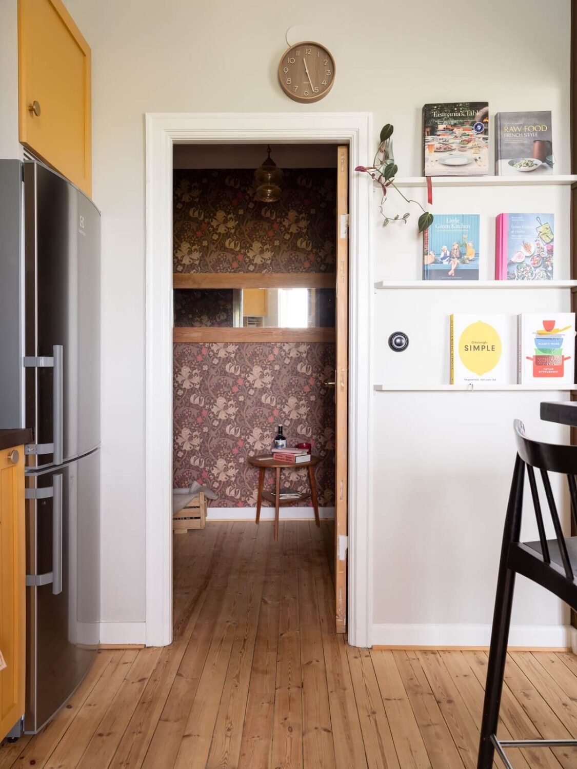 A Small Apartment with an Ochre Yellow Kitchen 14 view into wallpapered room