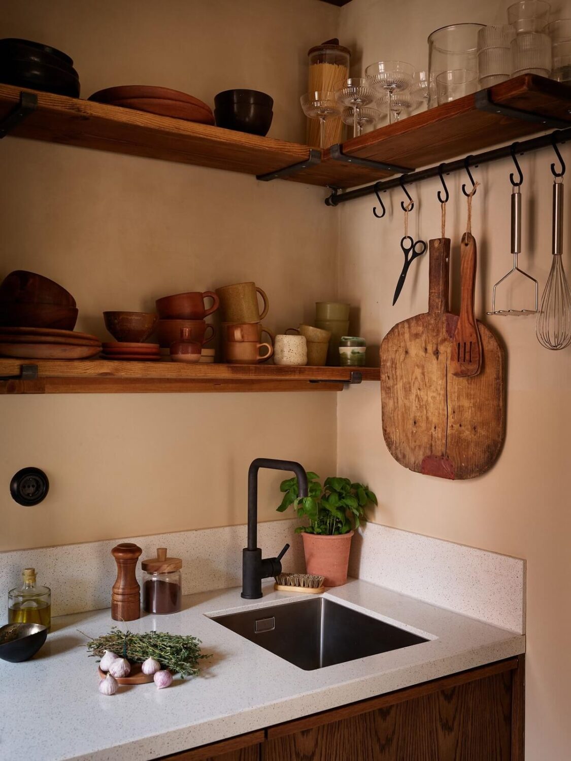 A Studio Apartment with Plaster Walls and a Walnut Kitchen 12 walnut kitchen with composite worktop black fittings and shelves nordroom