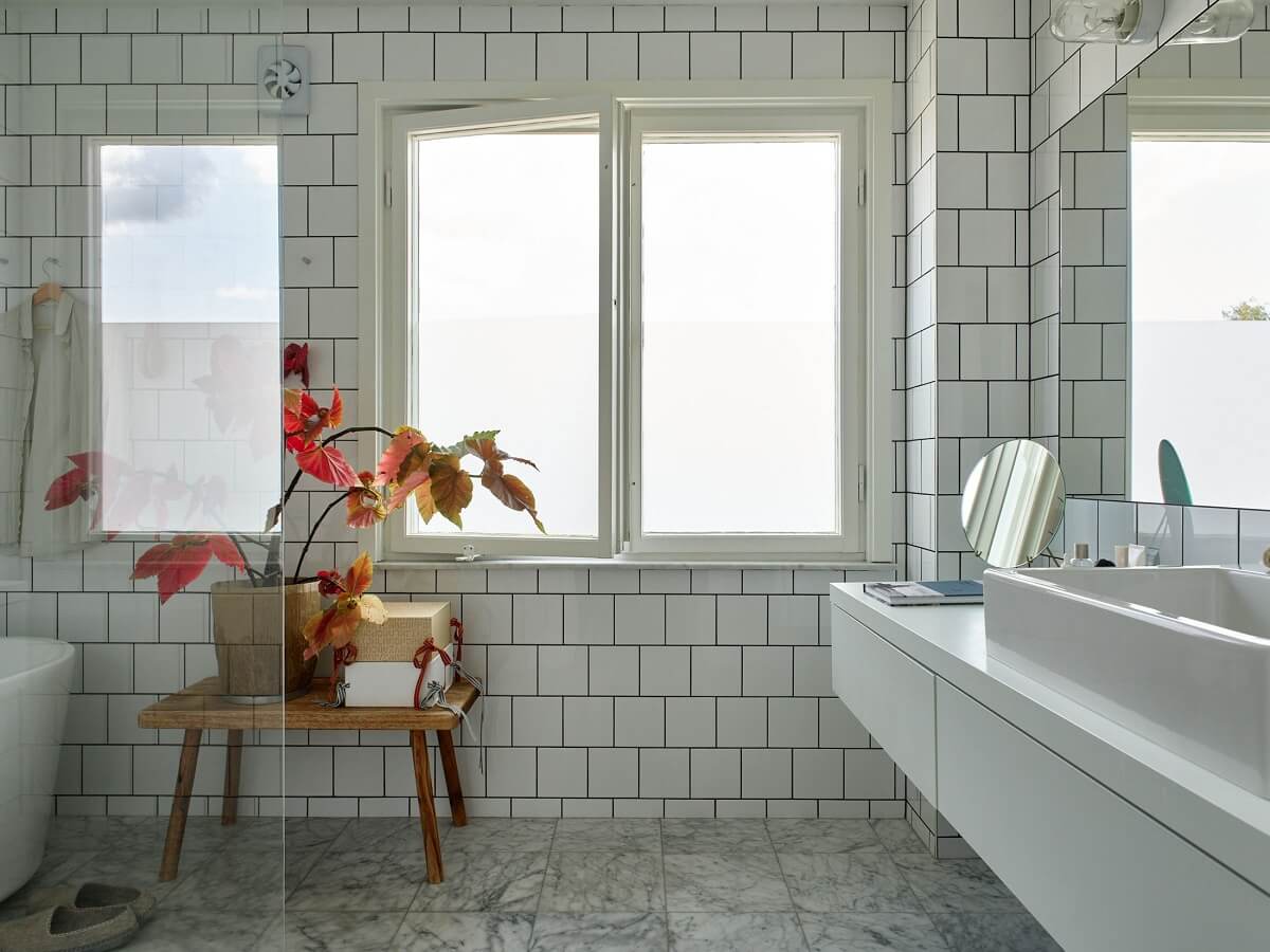 A 1940s House with Painted Floorboards in Sweden 19 white bathroom with floor to ceiling tilework