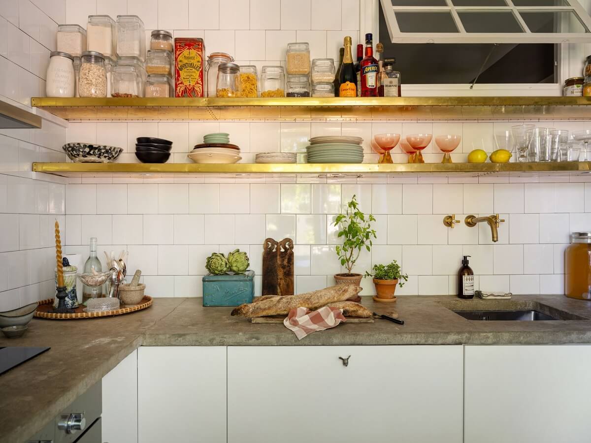 A Light and Well-Planned Apartment in Stockholm 13 white kitchen with gold shelves