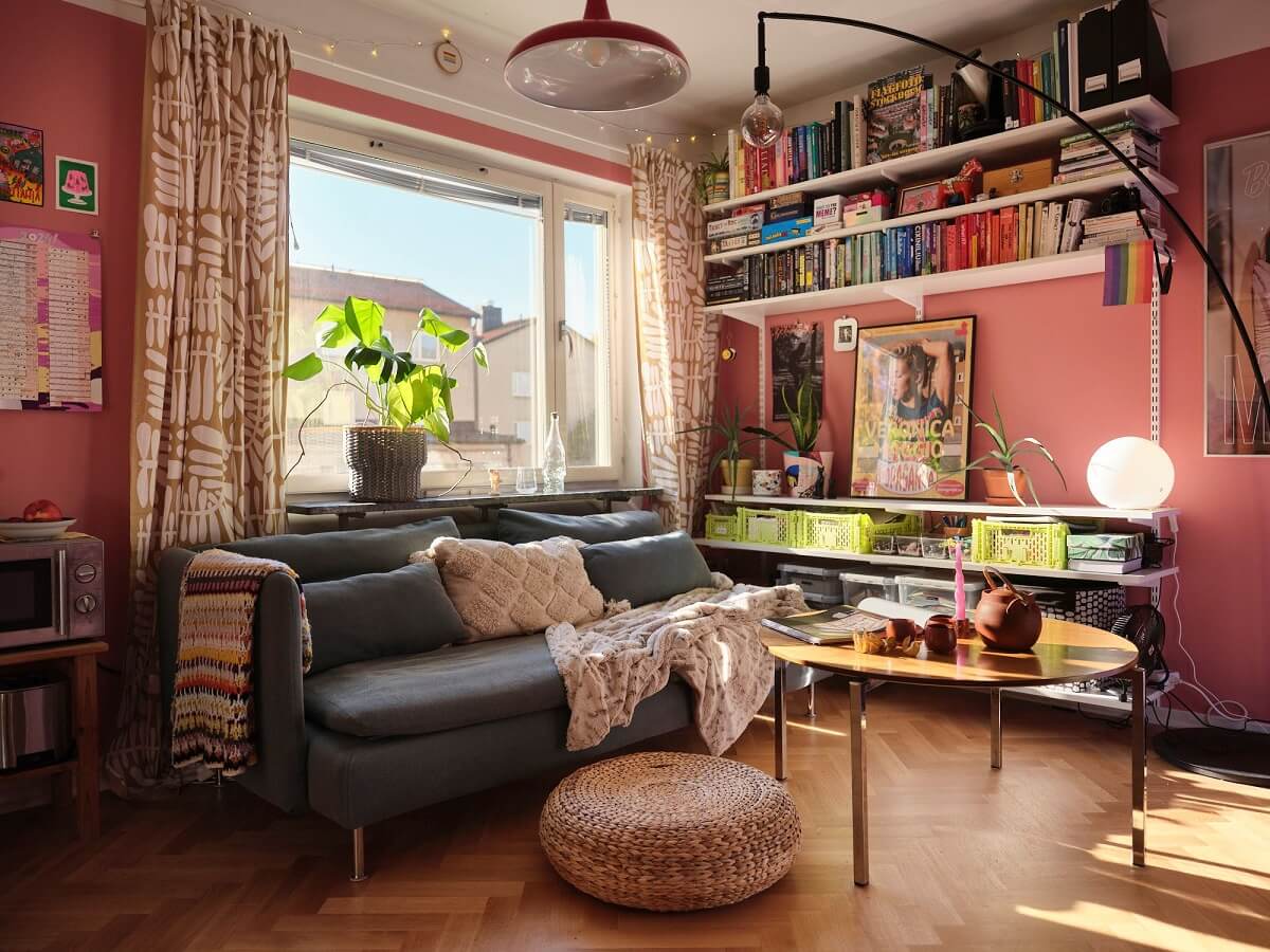 A Bold Pink Studio Apartment with a Light Yellow Kitchen 1 a pink studio apartment with bookshelves