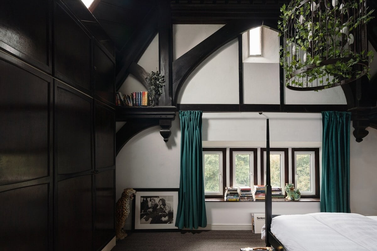 A Colorful Gothic-Style School Conversion in England 10 bedroom dark wooden beams teal curtains
