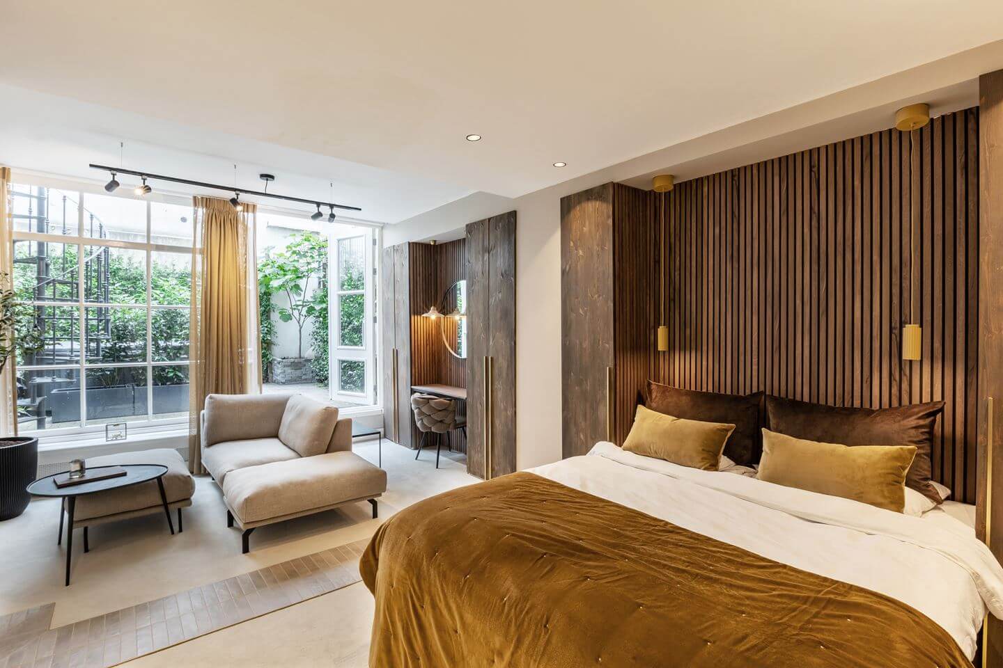 Hotel-Style Interiors in an Amsterdam Canal House 16 bedroom with wooden feature wall and ochre yellow color accents
