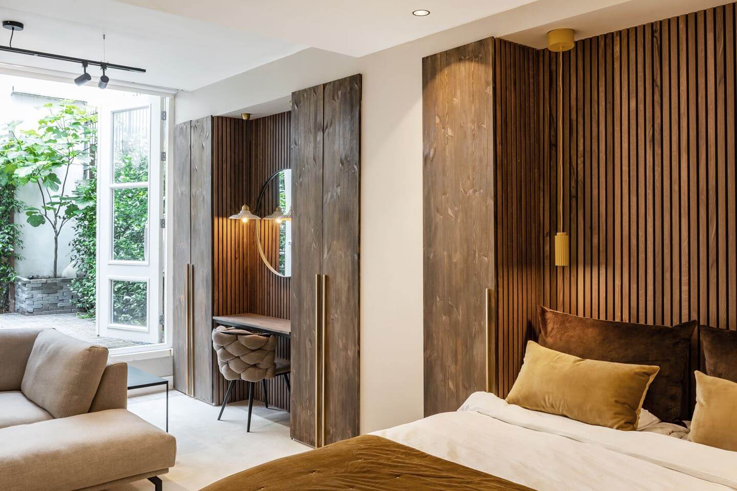 Hotel-Style Interiors in an Amsterdam Canal House 18 bedroom with wooden wall and desk