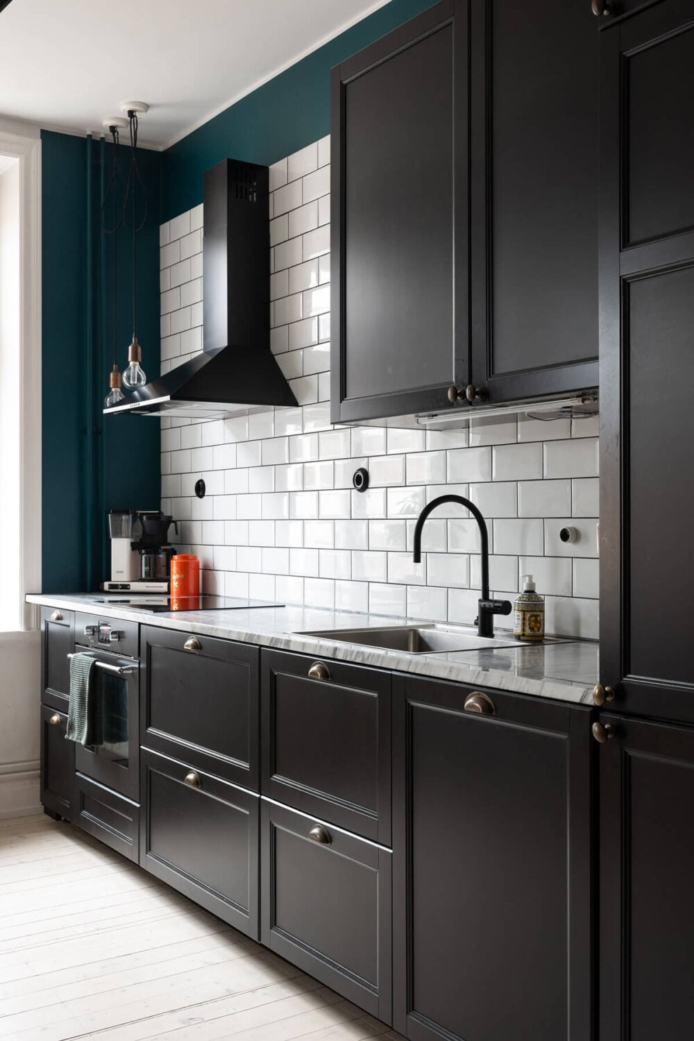 Colorful Art and Furniture in a Stylish Scandi Apartment 16 black kitchen cabinets white backsplash tiles