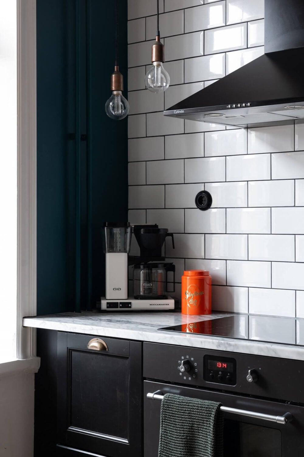 Colorful Art and Furniture in a Stylish Scandi Apartment 15 black kitchen with white tiles
