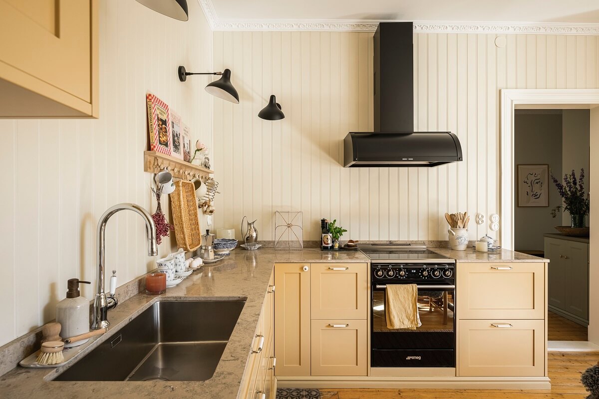 Hannes Mauritzson's Warm Yellow Hygge Apartment in Sweden 22 butter yellow kitchen pear rafters
