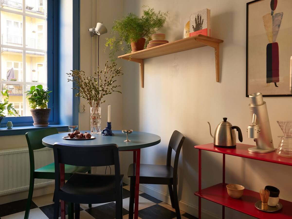 Golden Yellow Walls in a Colorful Swedish Studio Apartment 13 colorful kitchen with round table and checkerboard floor
