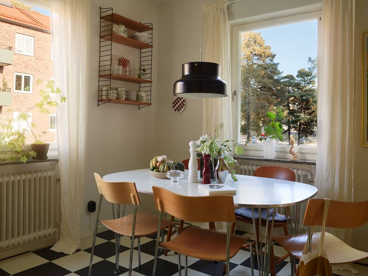Preserved Midcentury Details and a Red Bedroom in a Stockholm Apartment 13 dining space in midcentury kitchen with black and white checkerboard floor