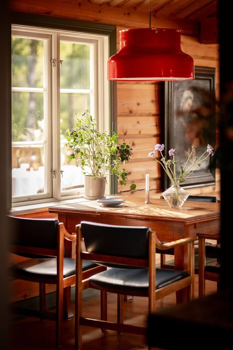 A Warm Scandinavian Log House with a Green Roof 7 dning table with red pendant