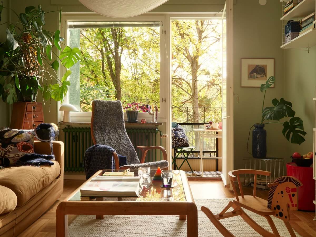 Preserved Midcentury Details and a Red Bedroom in a Stockholm Apartment 6 green living room with balcony and nature views