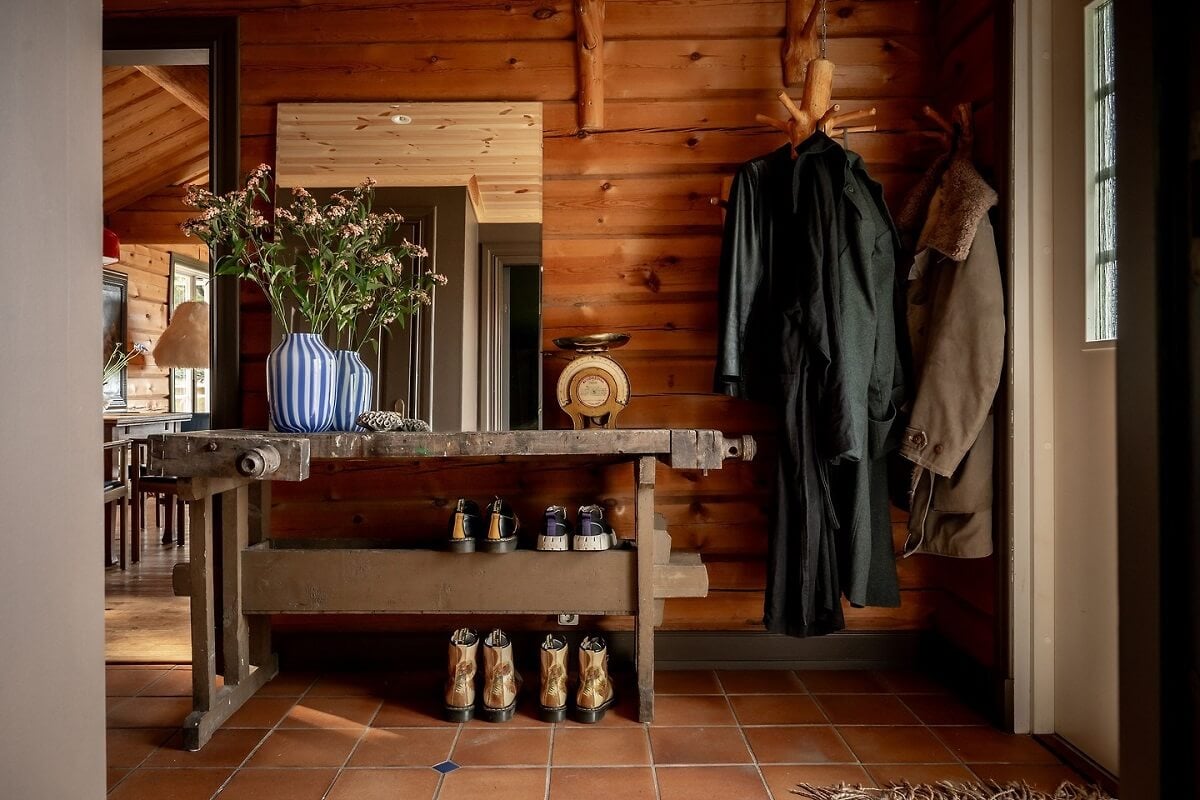 A Warm Scandinavian Log House with a Green Roof 15 hallway rustic side table