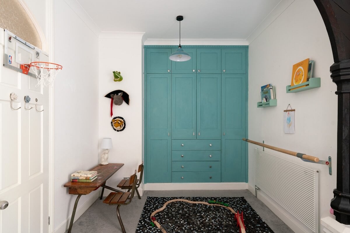A Colorful Gothic-Style School Conversion in England 15 kids bedroom with blue built in wardrobes