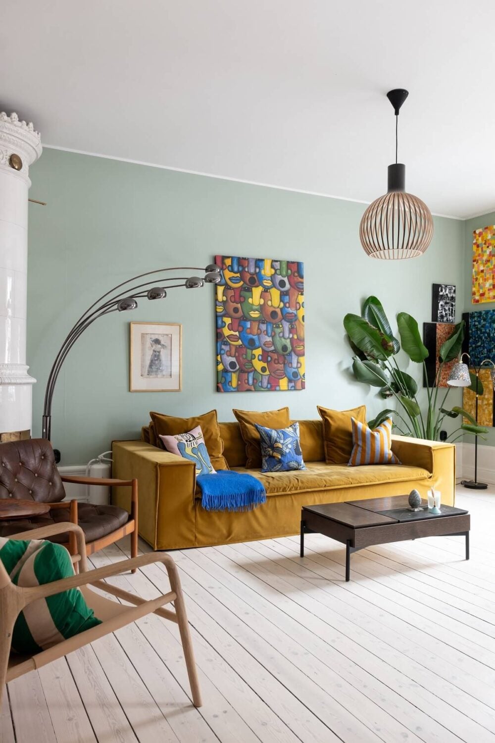 Colorful Art and Furniture in a Stylish Scandi Apartment 7 living room green walls ochre sofa wooden floor nordroom