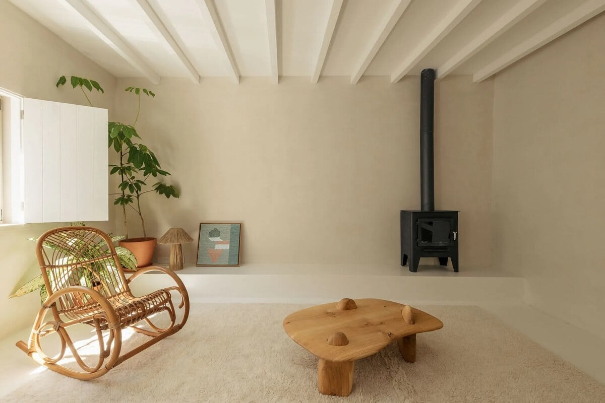 A Serene Minimalistic Townhouse in Portugal 2 living room wood burner rattan rocking chair