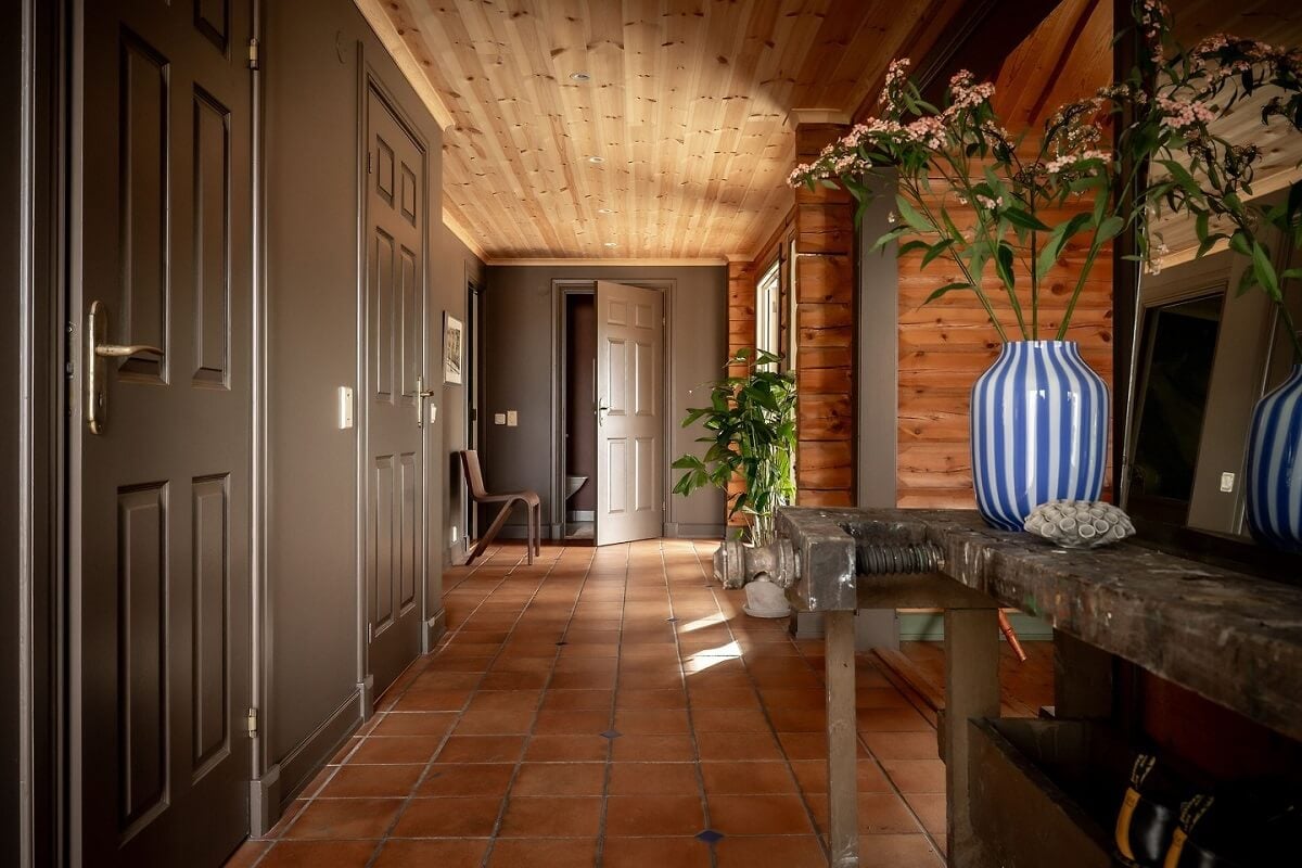 A Warm Scandinavian Log House with a Green Roof 14 log house hallway stone floor