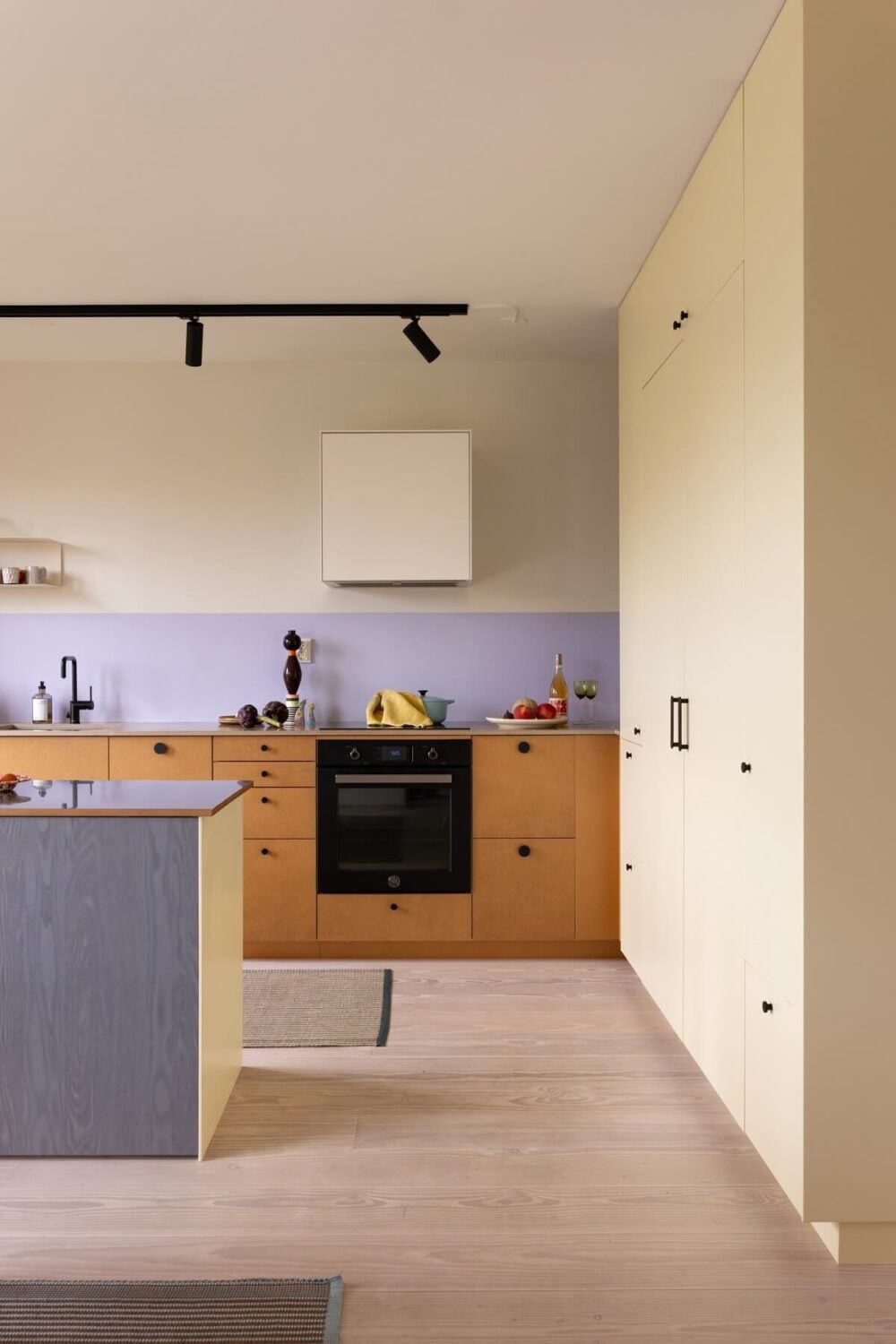 A Light and Modern Stockholm Apartment with Cheerful Color Accents 3 modern kitchen with island and lavender backsplash