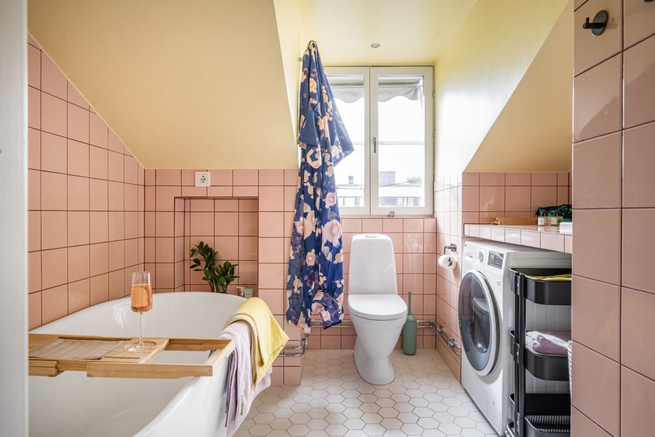 A Small, Colorful Attic Apartment with A Yellow Kitchen 22 pink and yellow bathroom with bath and slanted ceiling