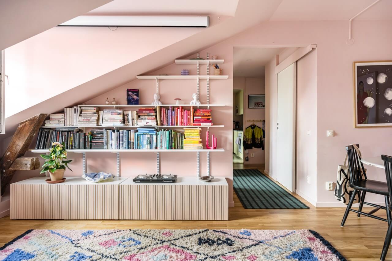 A Small, Colorful Attic Apartment with A Yellow Kitchen 3 pink living room with bookshelves