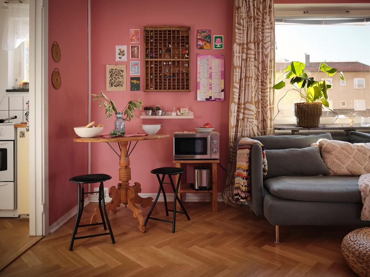A Bold Pink Studio Apartment with a Light Yellow Kitchen 8 pink studio with small round woodn table A Bold Pink Studio Apartment with a Light Yellow Kitchen